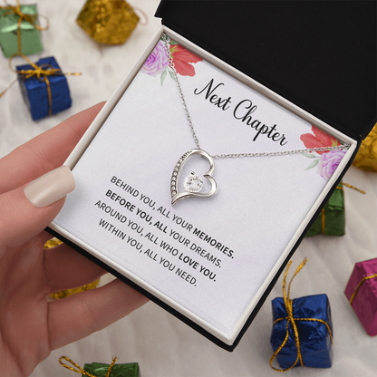 Silver open heart pendant necklace with a center stone, gifted with a "New Chapter" message.

